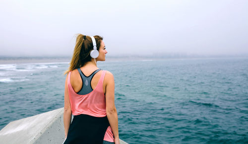 Woman standing on pier against sky