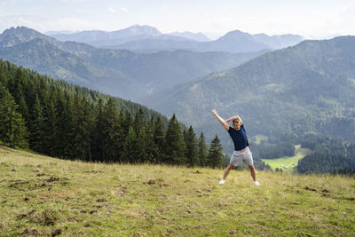 Full length of man with arms raised on mountain