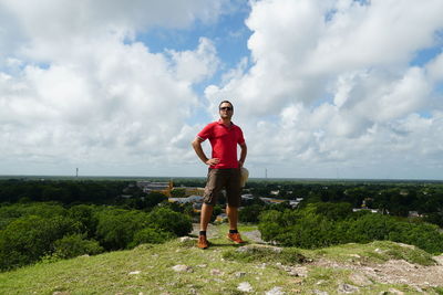 Portrait of man standing on plants against sky