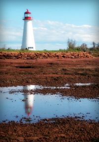 Lighthouse against cloudy sky