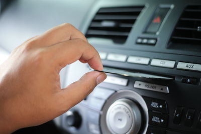 Close up hand with cd player in car
