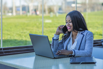 Woman looking at camera while sitting on table