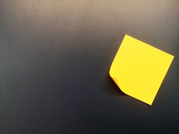 Close-up of yellow paper on wall