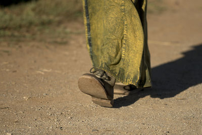 Low section of person walking on field
