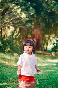 Portrait of young woman standing on field