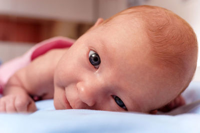 Close-up of baby boy lying on bed at home