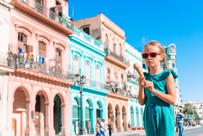 Young woman wearing sunglasses standing in city