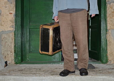 Low section of man standing by door