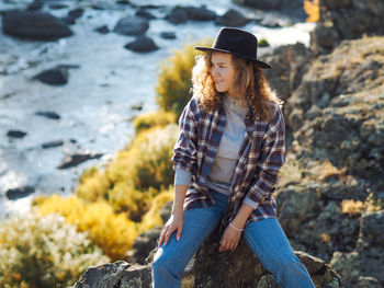 Woman wearing hat on rock