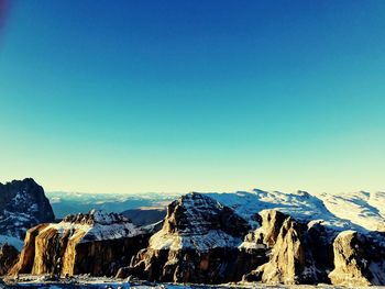 Scenic view of sea and mountains against clear blue sky