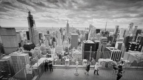 Buildings in city against cloudy sky