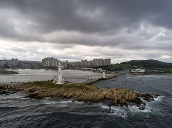 Scenic view of sea by city against sky