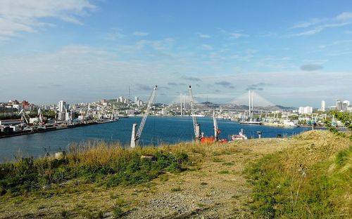 Sailboats in sea with city in background