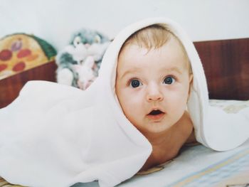 Cute baby boy lying on bed at home