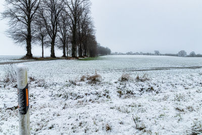 Scenic view of snow covered field against sky