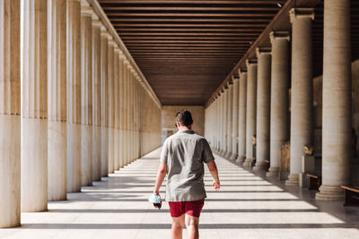 Rear view of man walking on footpath