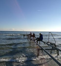 People on beach against clear sky