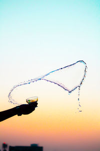 Low angle view of bubbles against clear sky at sunset