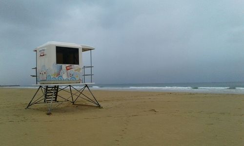 Lifeguard hut on beach against sky