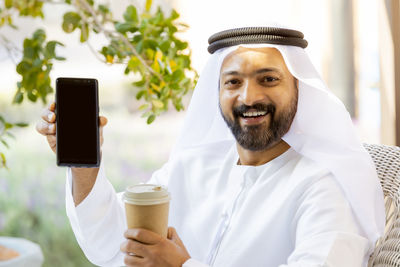 Portrait of man holding coffee cup