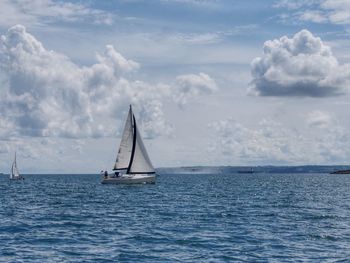 Sailboat sailing on sea against sky