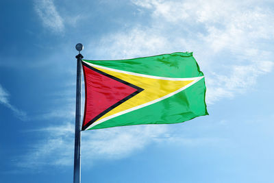 Low angle view of flag against blue sky