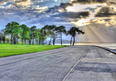 Road amidst trees against sky