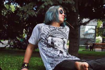 Teenage boy looking away while sitting in park