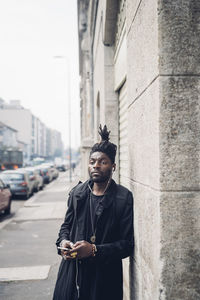 Portrait of young man looking at city street