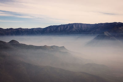 Scenic view of rocky mountains against sky during foggy weather