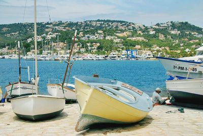 Sailboats moored on sea against sky