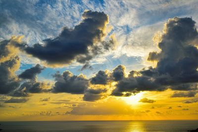 Scenic view of sea against dramatic sky during sunset