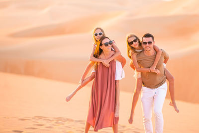 Portrait of women wearing sunglasses standing on beach