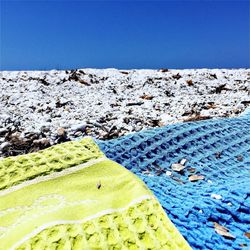 Close-up of beach against clear blue sky