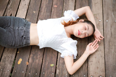 High angle view of woman lying on wooden floor