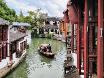 Boats in canal amidst buildings