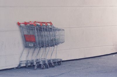 Shopping carts on sidewalk against wall