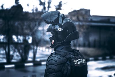 Close-up of person wearing helmet in city during rainy season