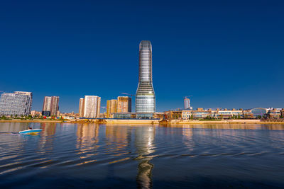 Buildings in city against clear blue sky