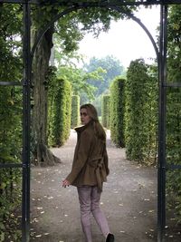 Woman standing by tree in forest