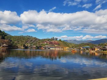 Scenic view of lake by buildings against sky