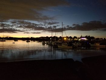 Silhouette sailboats moored in sea at sunset