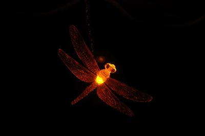 Close-up of illuminated lamp over black background