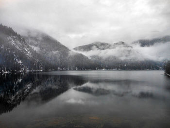 Scenic view of lake by mountains against sky