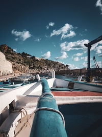 Low angle view of oar and boat against sky