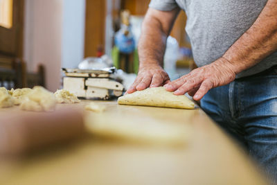 Midsection of chef preparing fresh mona de pascua on kitchen counter at restaurant