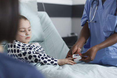 Midsection of doctor examining patient in hospital