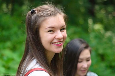 Close-up portrait of smiling teenage girl outdoors
