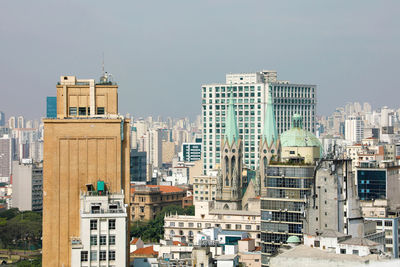 Buildings in city against clear sky