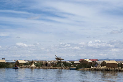 Houses by sea against sky